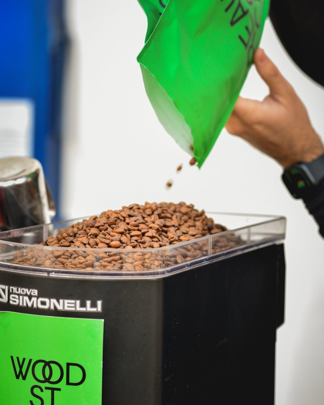Beans tipping from a Wood St Coffee bag into the hopper