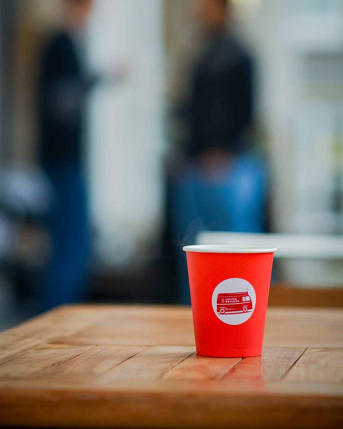 A Coffee Brigade cup of coffee on a wooden table